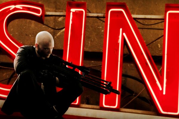 Hitman шукає мету на тлі напису