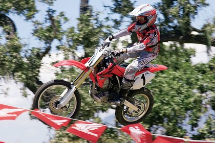 Гонщик злітає на байку вище прапорців